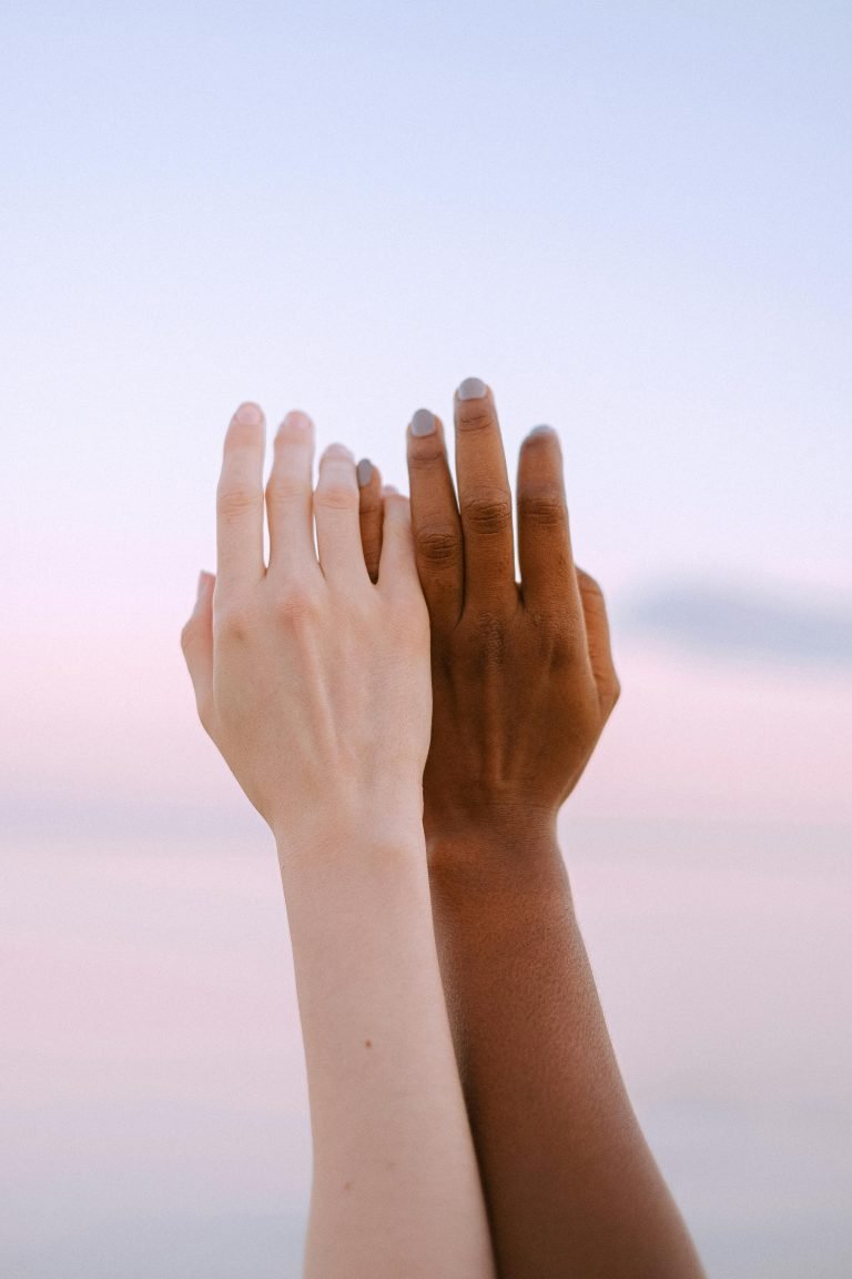 Zwei Arme nebeneinander mit sich leicht berührenden Fingern