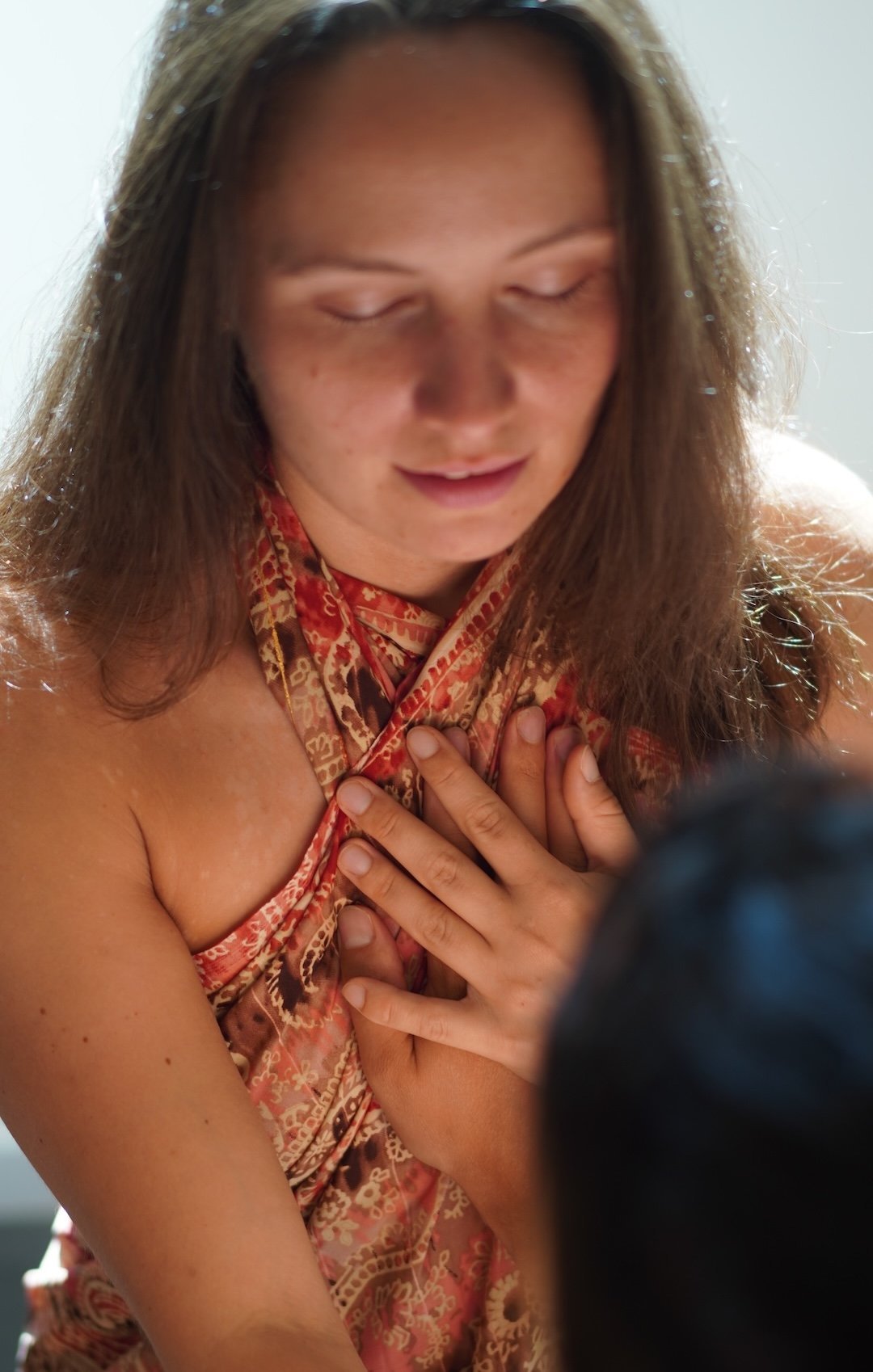 Tantrische Atemübung mit beiden Händen auf die Brust gelegt.